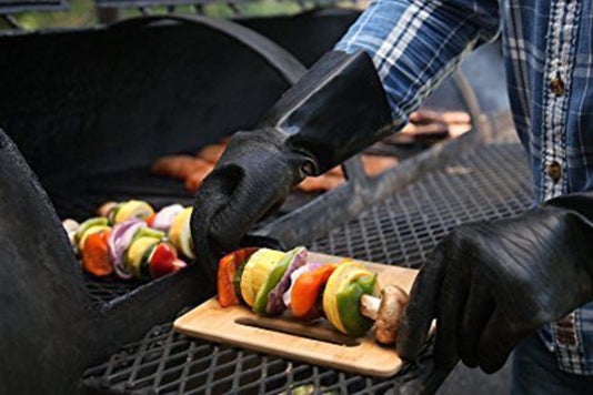Person using the Pit Glove Insulated Gloves at a grill.